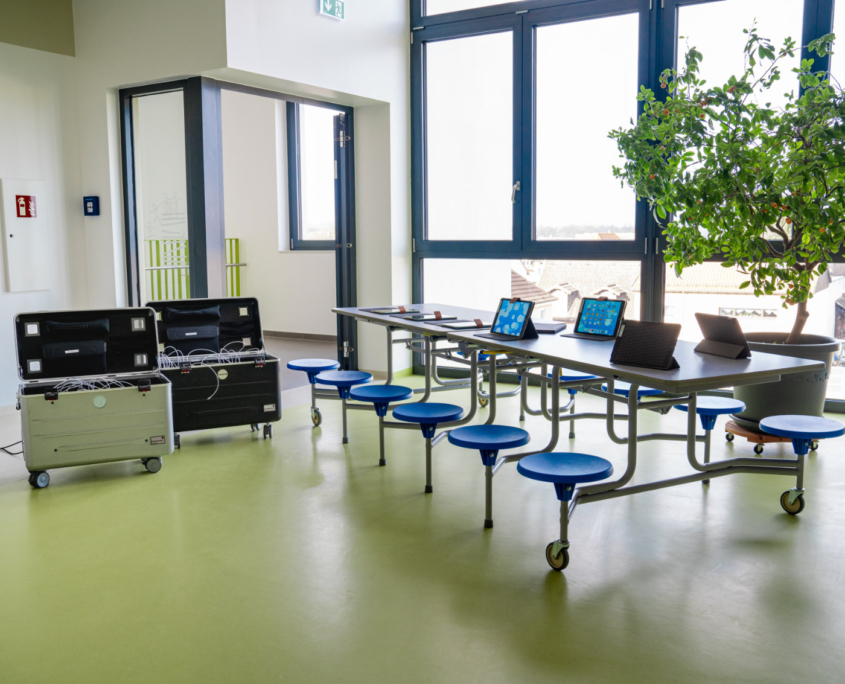 12 Rundhocker an einem Tisch befestigt mit aufgestellten Computerpads und 2 Pad Roll Containern 12 Rundhocker an einem Tisch befestigt mit aufgestellten Computerpads und 2 Pad Roll Containern