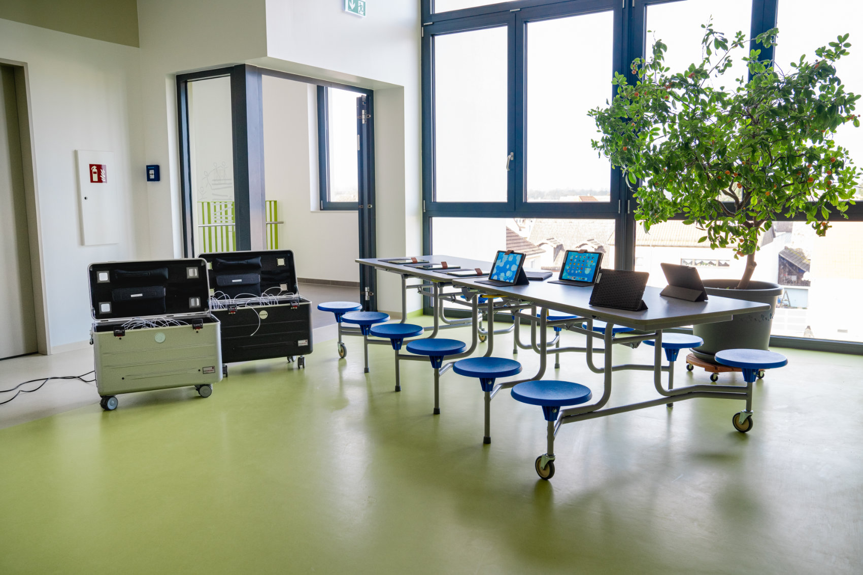 12 Rundhocker an einem Tisch befestigt mit aufgestellten Computerpads und 2 Pad Roll Containern 12 Rundhocker an einem Tisch befestigt mit aufgestellten Computerpads und 2 Pad Roll Containern