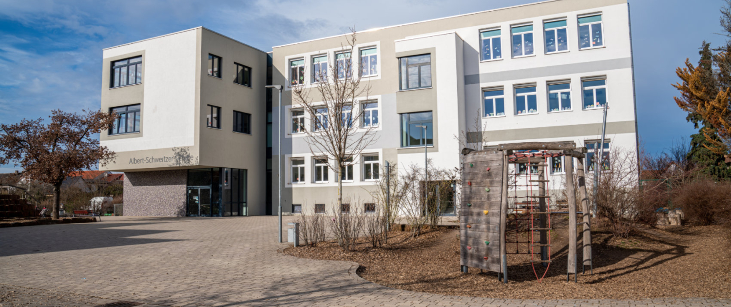 Das Schulgebäude von rechts vorne mit Klettergerüst davor Das Schulgebäude von rechts vorne mit Klettergerüst davor