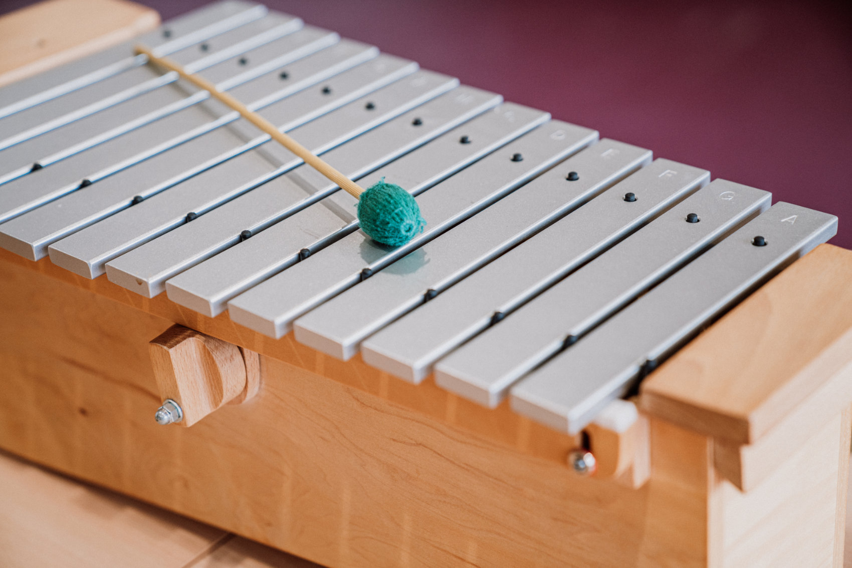 Hölzernes Xylophon mit Alu Klangstäben und einem Klöppel in schräger Draufsicht Hölzernes Xylophon mit Alu Klangstäben und einem Klöppel in schräger Draufsicht