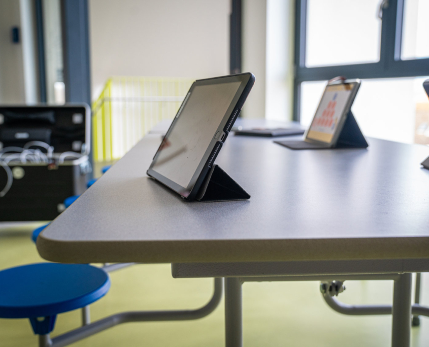 Mehrere Computerpads stehen und liegen auf einem Tisch und daneben steht ein Aufbewahrungscontainer Mehrere Computerpads stehen und liegen auf einem Tisch und daneben steht ein Aufbewahrungscontainer