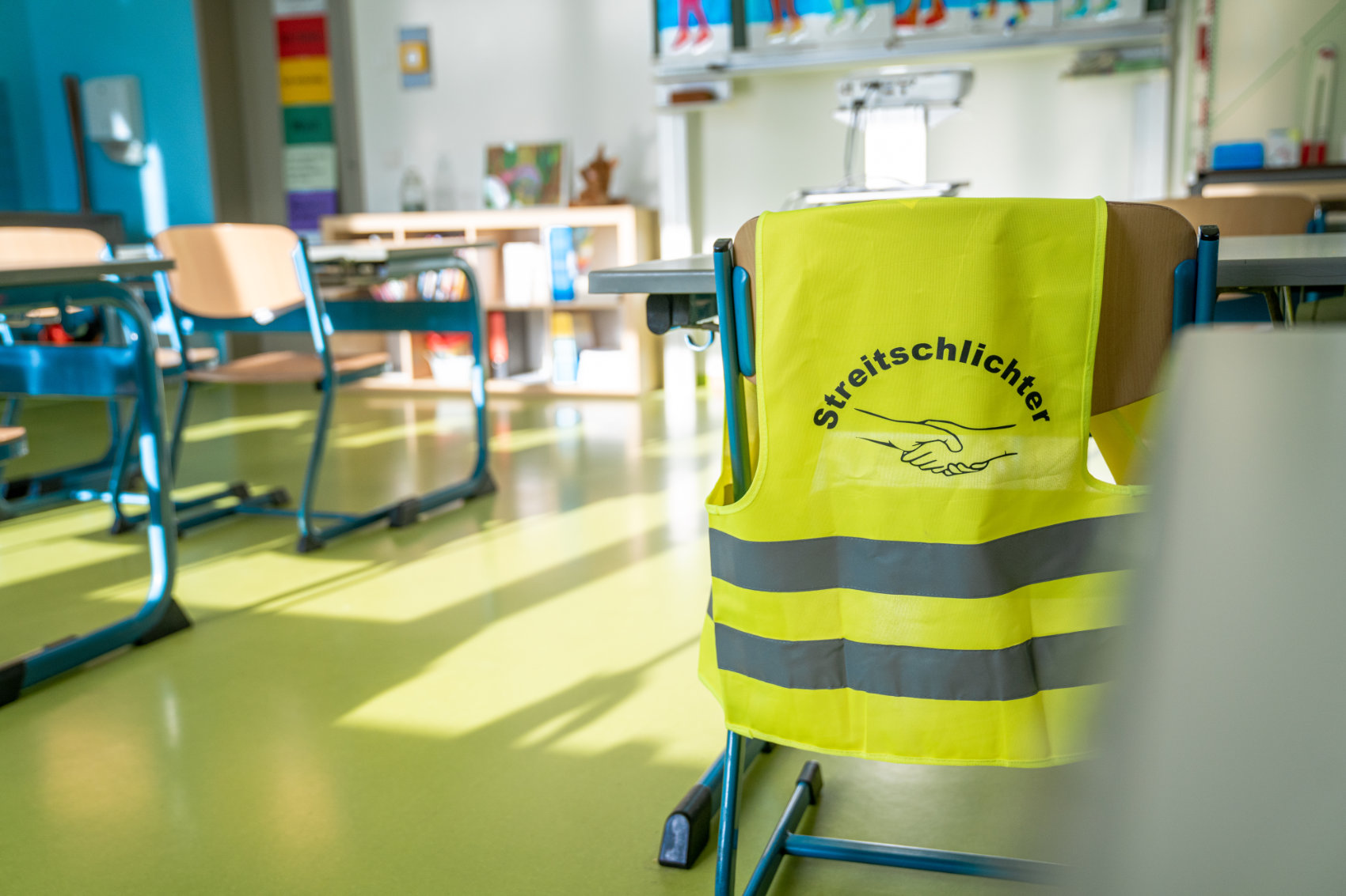 Streitschlichterweste über einer Stuhllehne in einem Klassenzimmer Streitschlichterweste über einer Stuhllehne in einem Klassenzimmer